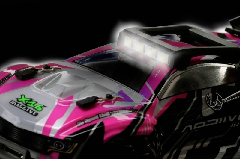 Zdalnie sterowany samochód w jaskrawym różowym kolorze z reflektorami LED na dachu, zaprojektowany do szybkich wyścigów i ekstremalnych akrobacji.