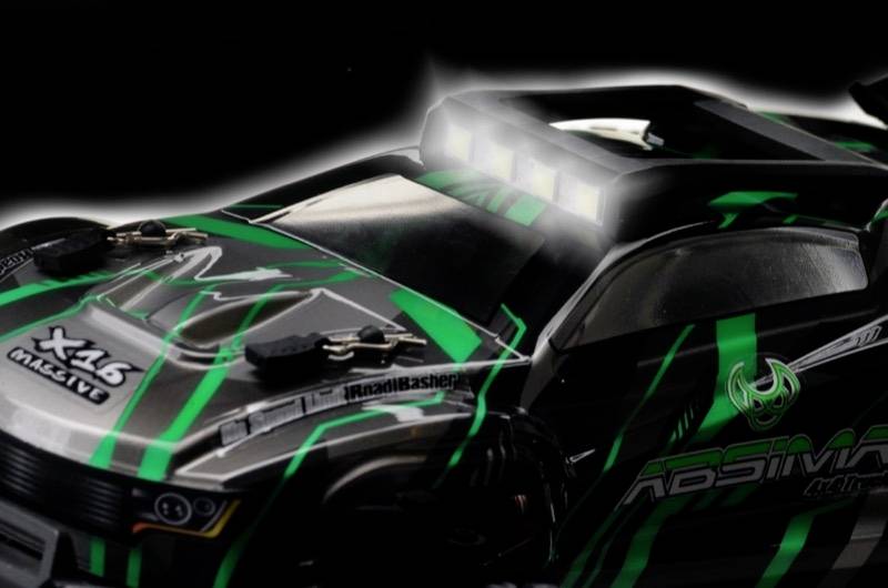 Zdalnie sterowany samochód w kolorach czarnym i zielonym z jasnymi reflektorami, sportową stylistyką oraz napisem 'X46 MacFly'.