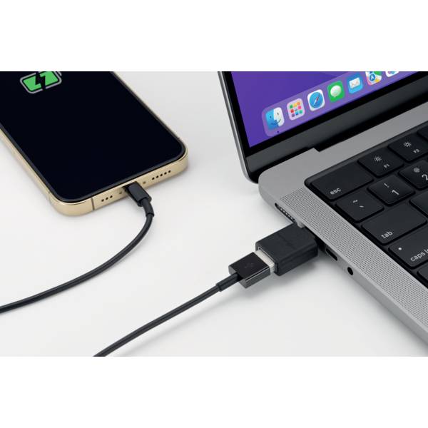 Laptop i smartfon połączone kablem USB-C. Na ekranie laptopa widoczne są otwarte aplikacje, a wyświetlacz smartfona pokazuje symbol ładowania.