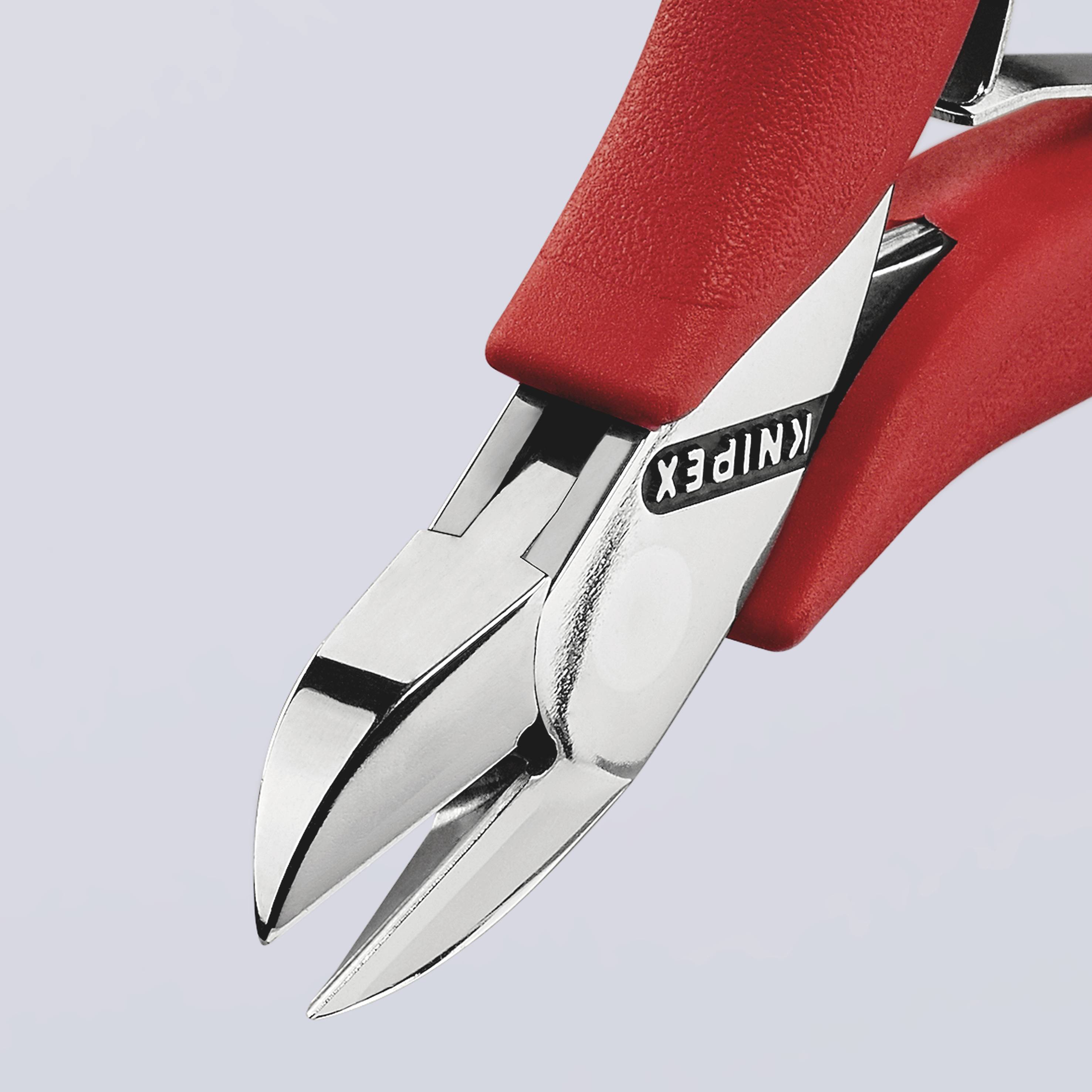 Czerwone szczypce z czarną rękojeścią; przedstawiające zbliżenie powierzchni tnącej. Nazwa marki 'Knipex' widoczna z boku.