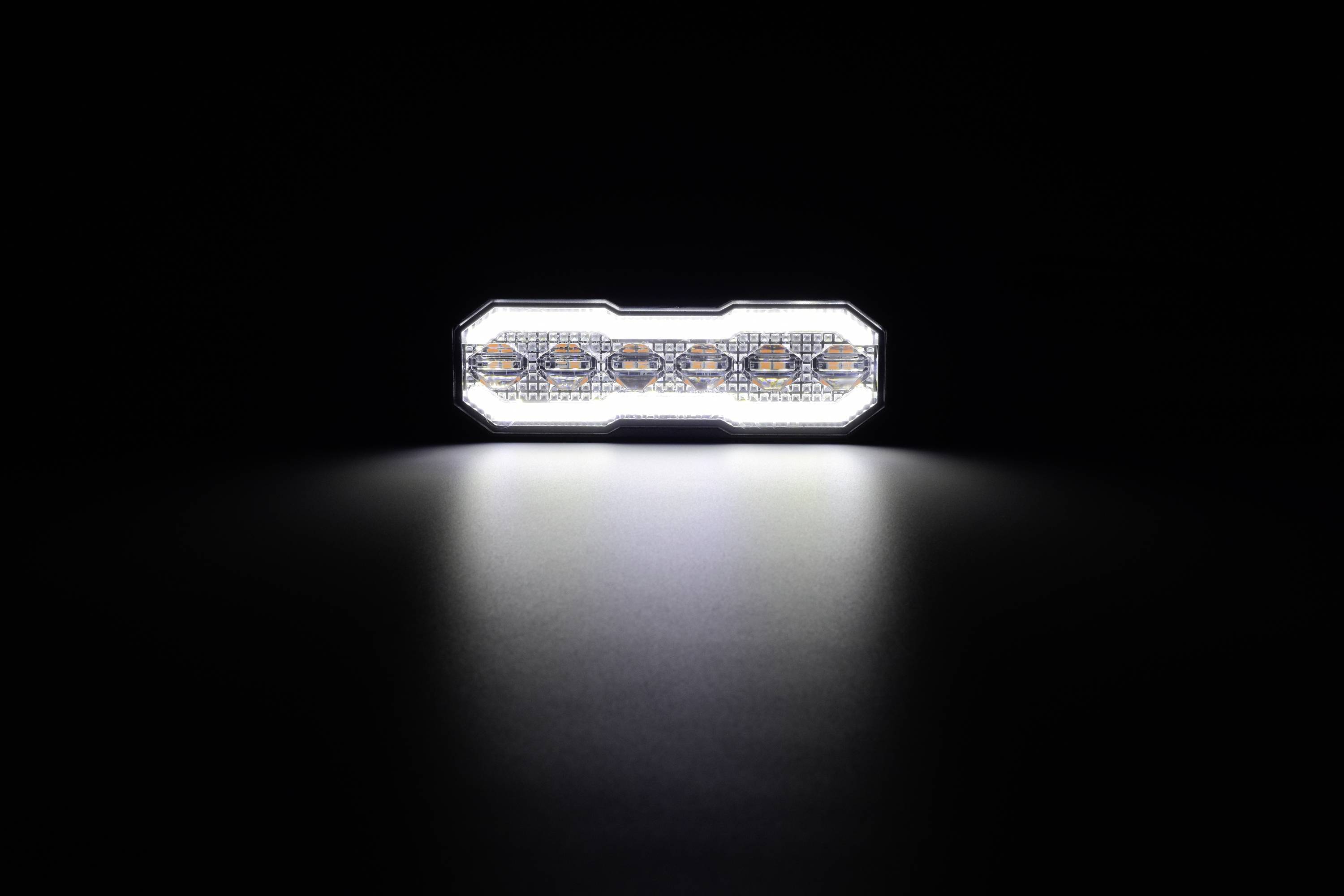 Prostokątna belka świetlna LED świecąca w ciemności, rzucająca jasny, skupiony strumień światła na powierzchnię poniżej.