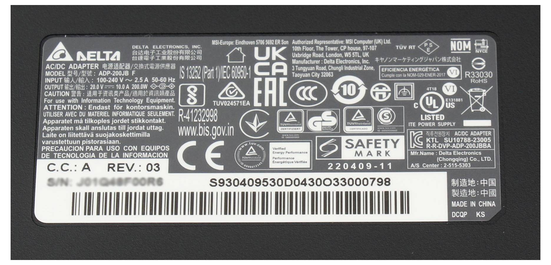 Etykieta zasilacza z numerem modelu, specyfikacjami elektrycznymi (wyjście: 19,5V, 3,34A, 65W) oraz certyfikatami bezpieczeństwa.