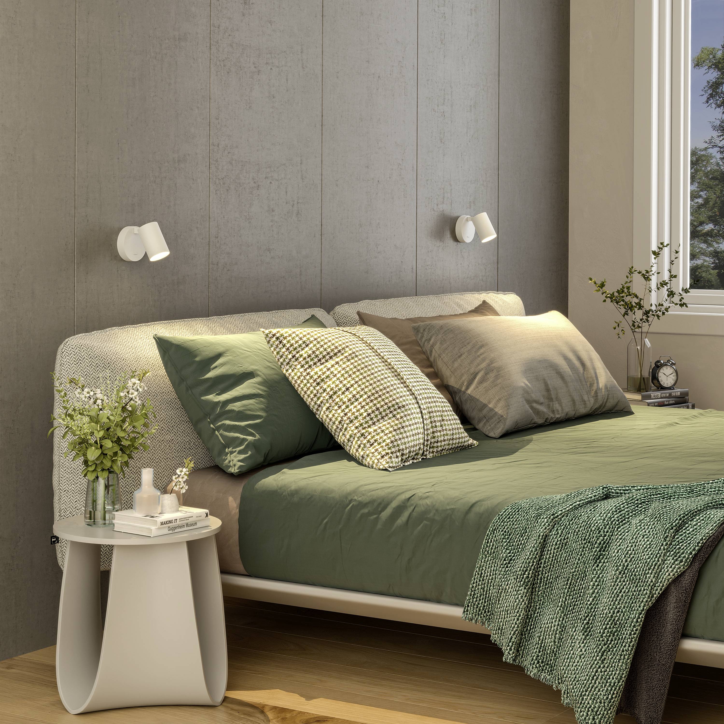 Przytulna sypialnia z podwójnym łóżkiem, zieloną pościelą, drewnianą boazerią na ścianie oraz rośliną stojącą na białym stoliku nocnym.