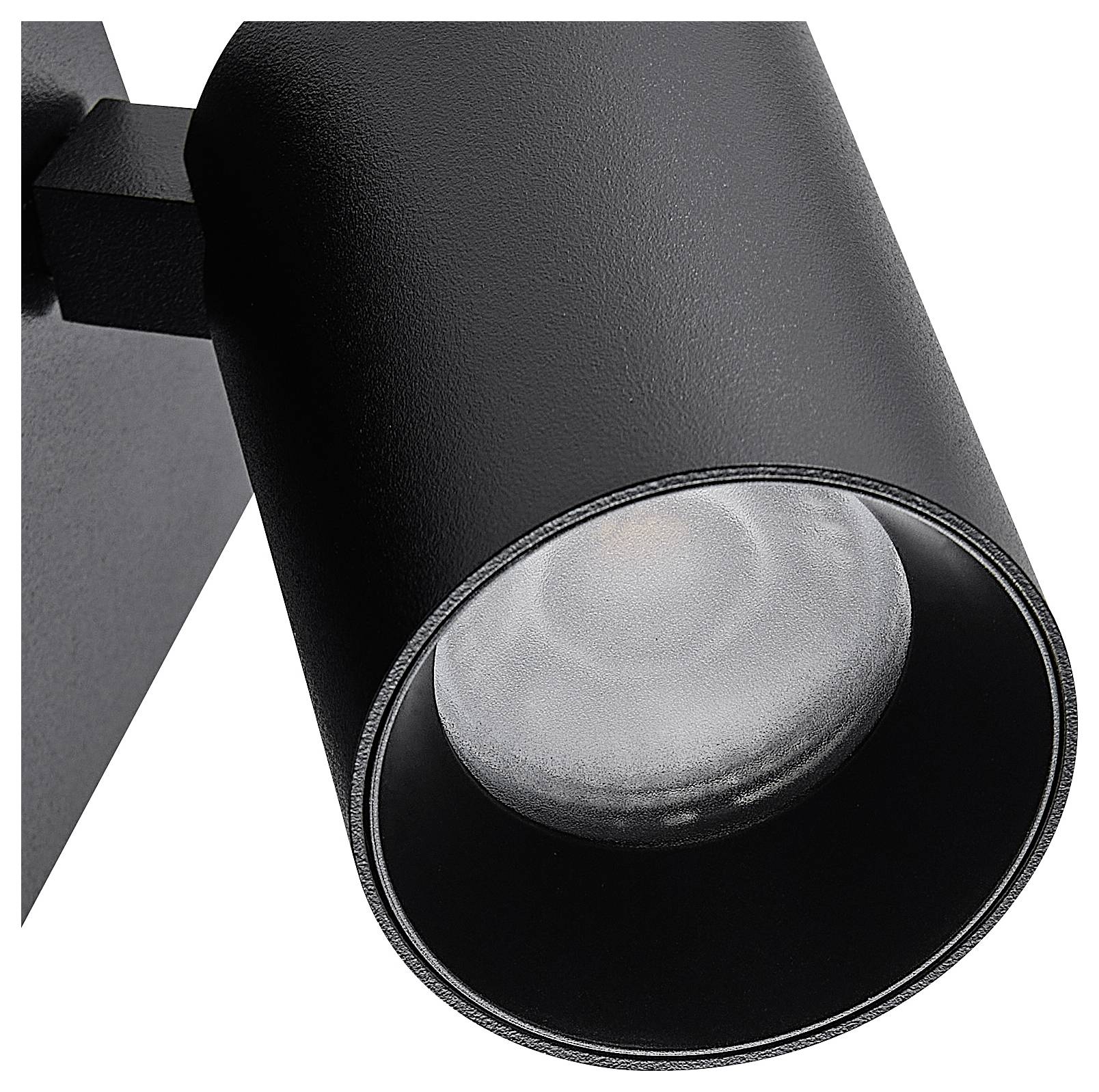 Czarna, cylindryczna lampa sufitowa o nowoczesnym designie, rzucająca skoncentrowane światło.