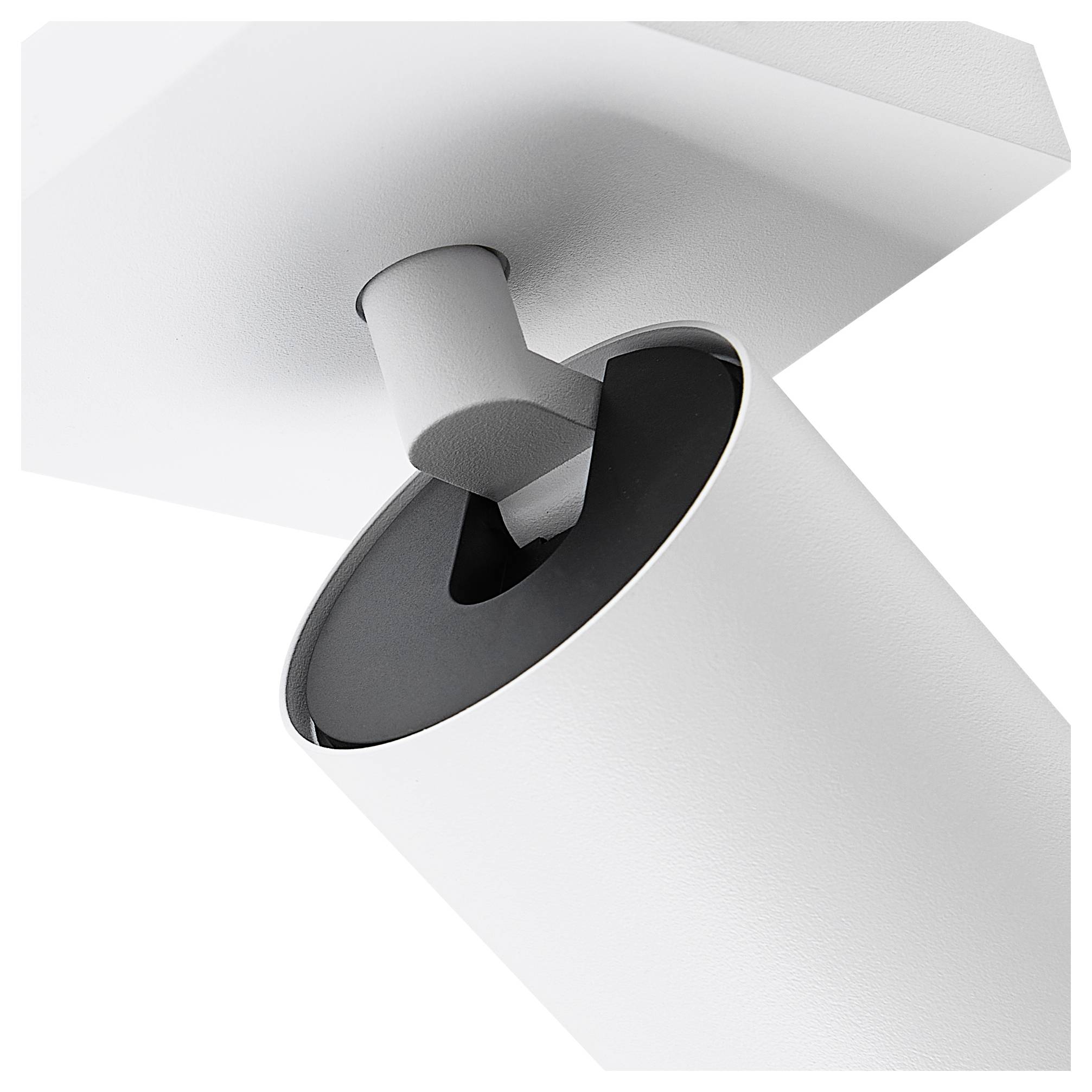 Biała, cylindryczna lampa sufitowa o nowoczesnym designie, skierowana w dół, sfotografowana pod skosem z boku.