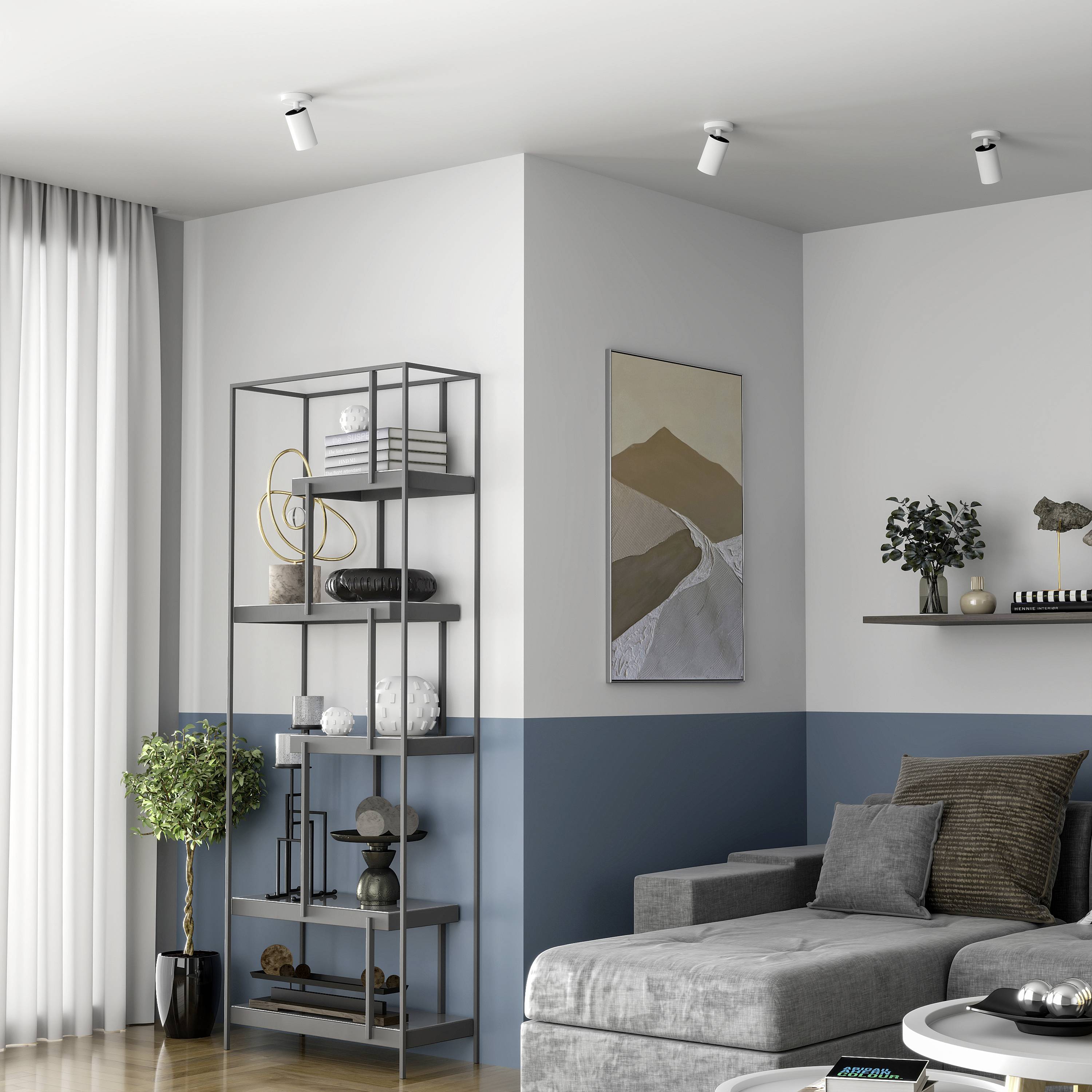 Nowoczesny salon z szarą sofą, abstrakcyjnymi obrazami, dekoracyjnymi półkami i roślinami. Neutralne kolory ścian tworzą spokojną atmosferę.