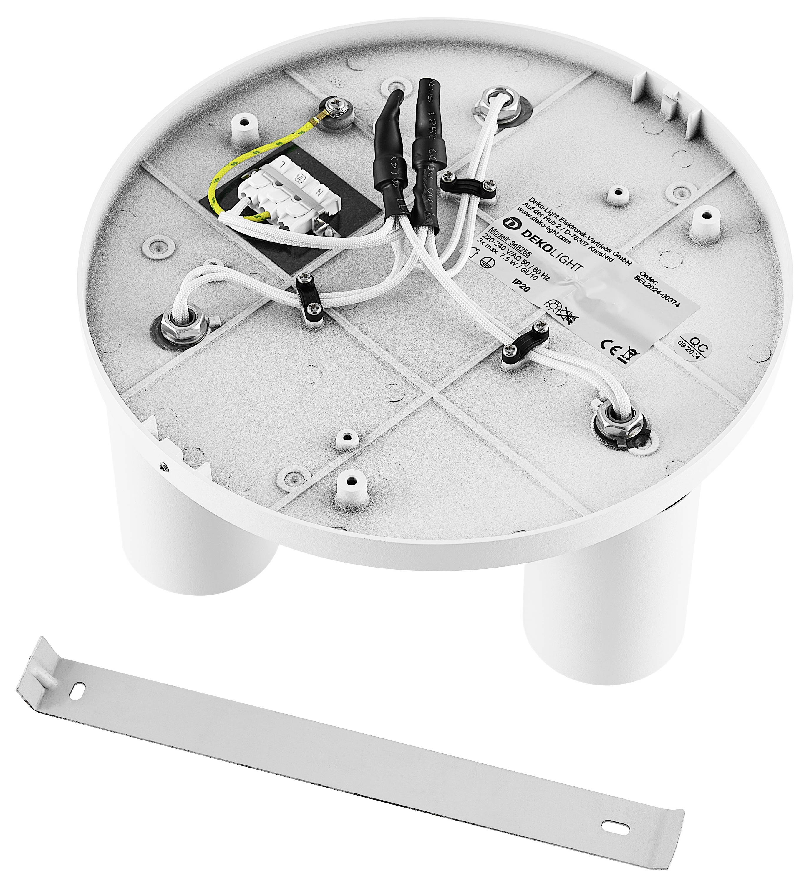 Okrągła, biała lampa bez osłony, z widocznymi przewodami i złączami; obok niej leży wąska metalowa podstawa.