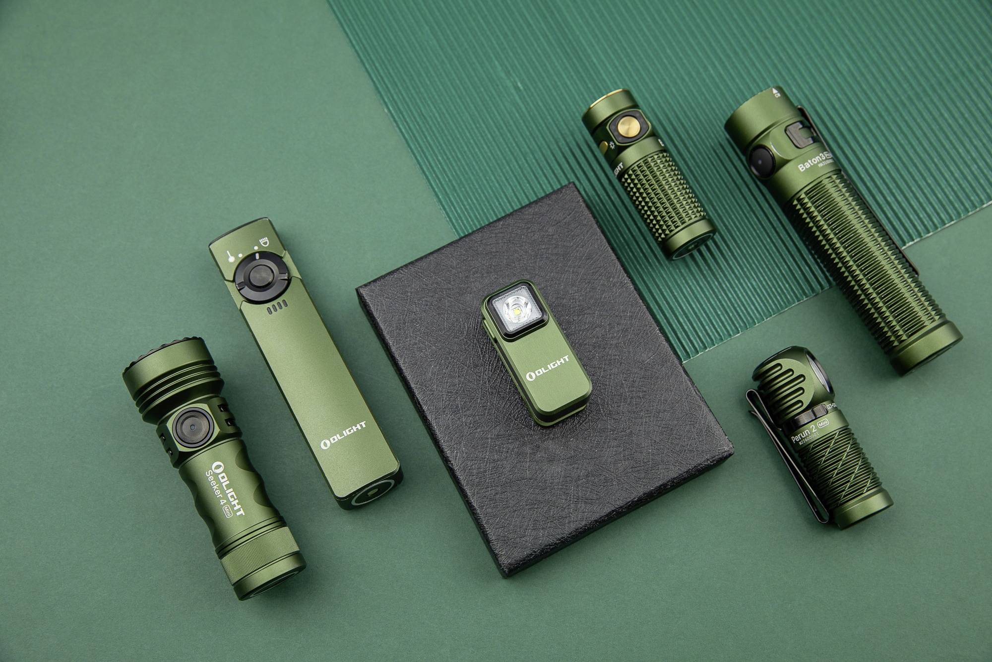 Kilka zielonych latarek o różnych kształtach i rozmiarach ułożonych jest na zielonym podłożu.