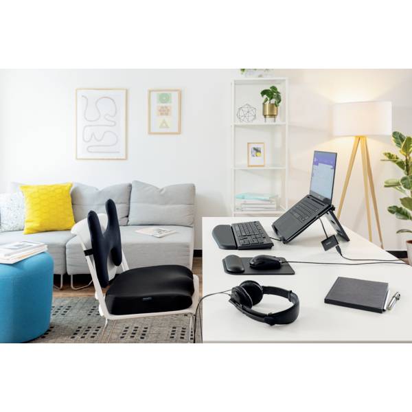 Nowoczesne, ergonomiczne biuro domowe. Po lewej stronie szara sofa, po prawej biurko z laptopem, ergonomiczną myszką i klawiaturą.