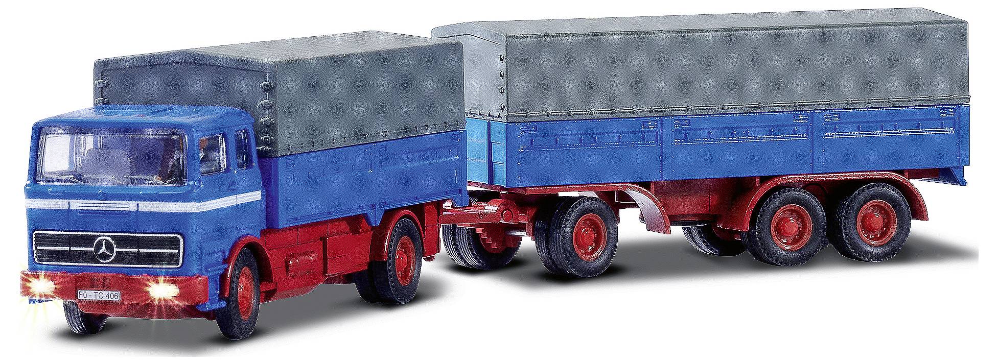 Niebieski, zabytkowy ciężarówka Mercedes z przyczepą, oba przykryte szarą plandeką, jedzie po jasnej nawierzchni.