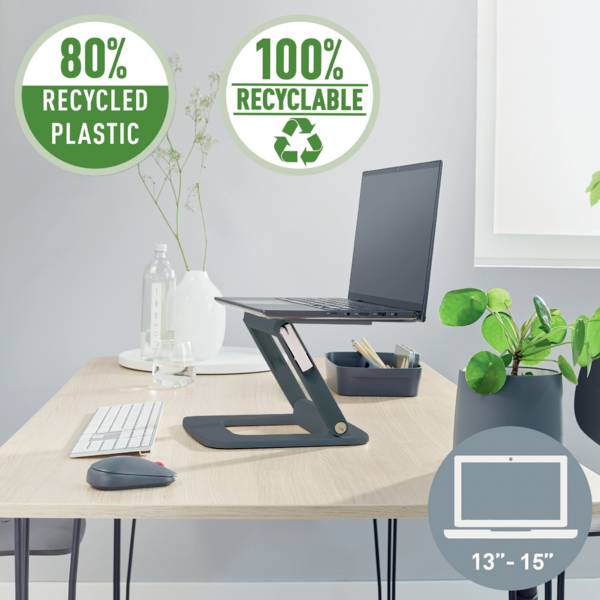 Laptop stoi na regulowanym stojaku na biurku. Naklejki informują '80% przetworzonego plastiku' i '100% nadające się do recyklingu'.