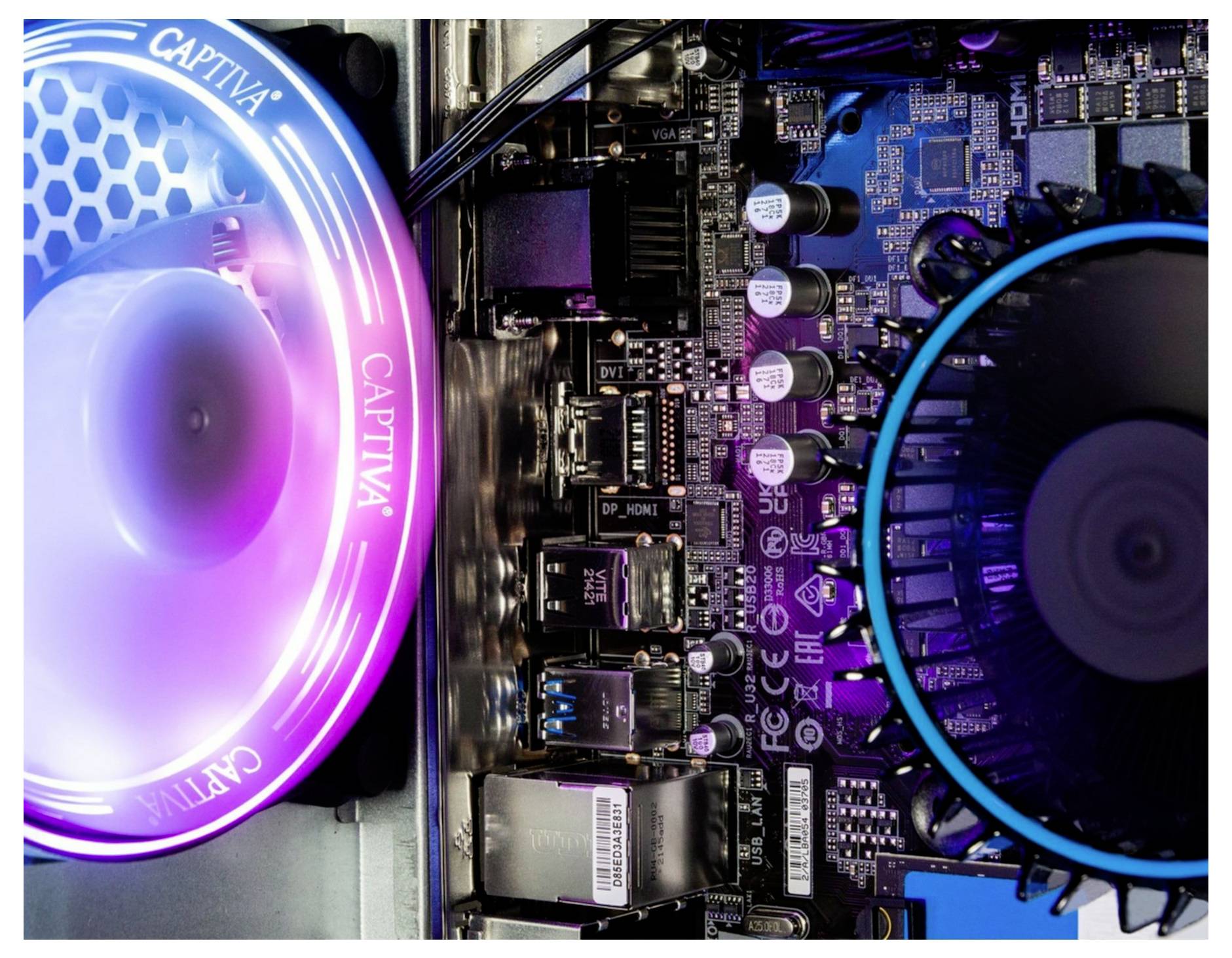 Płyta główna komputera z podświetlanymi wentylatorami w kolorach różowym i niebieskim, prezentująca widok wnętrza komputera z dokładnie widocznymi elementami elektronicznymi.