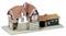 Model małego budynku dworcowego z czerwonym dachem z dachówki, ścianami w kolorze beżowym i dobudówką z ciemnego drewna.
