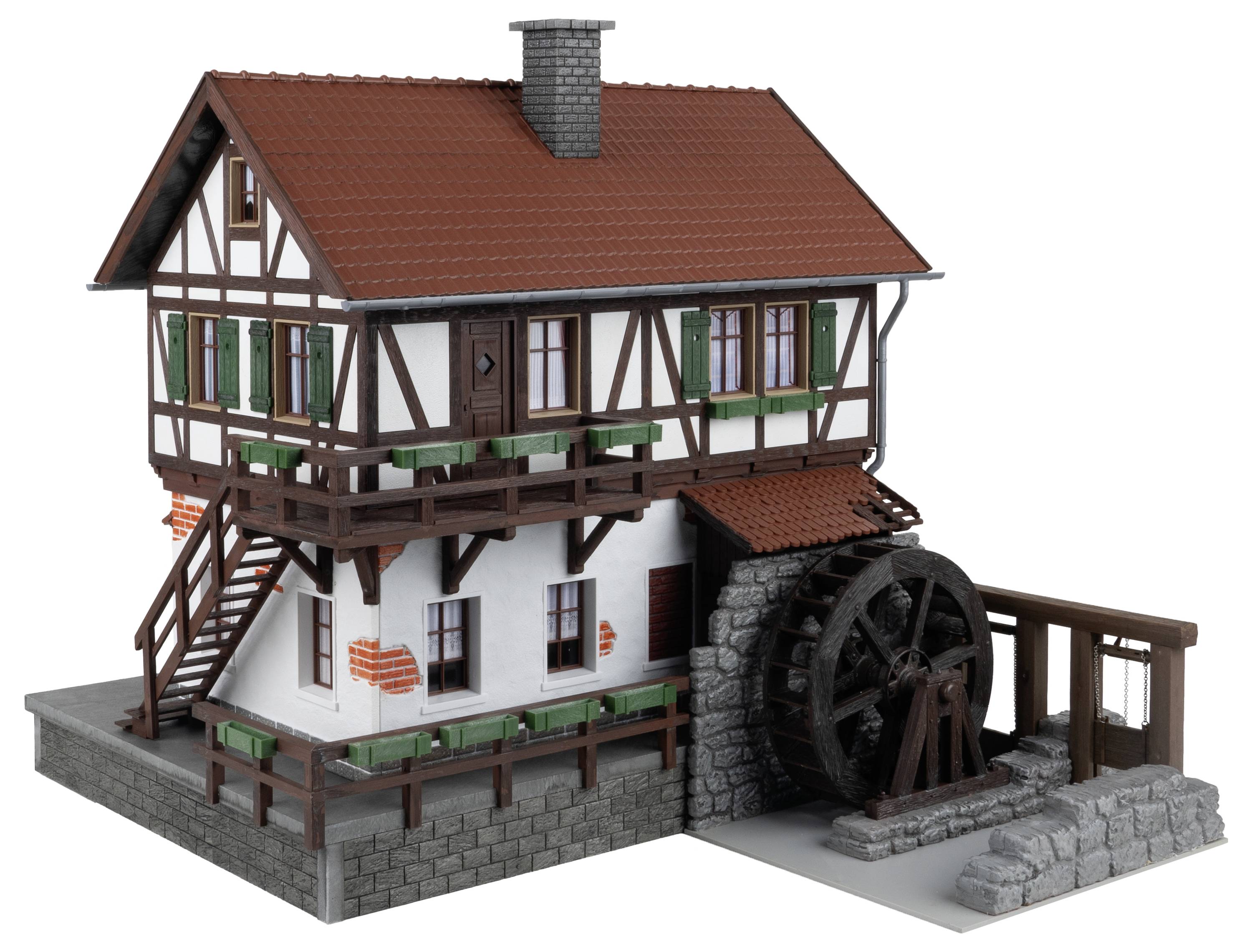 Dom w stylu muru pruskiego z czerwonym dachem ceramicznym, drewnianymi belkami i zamontowanym kołem wodnym. Schody prowadzą do wejścia na górnym poziomie.