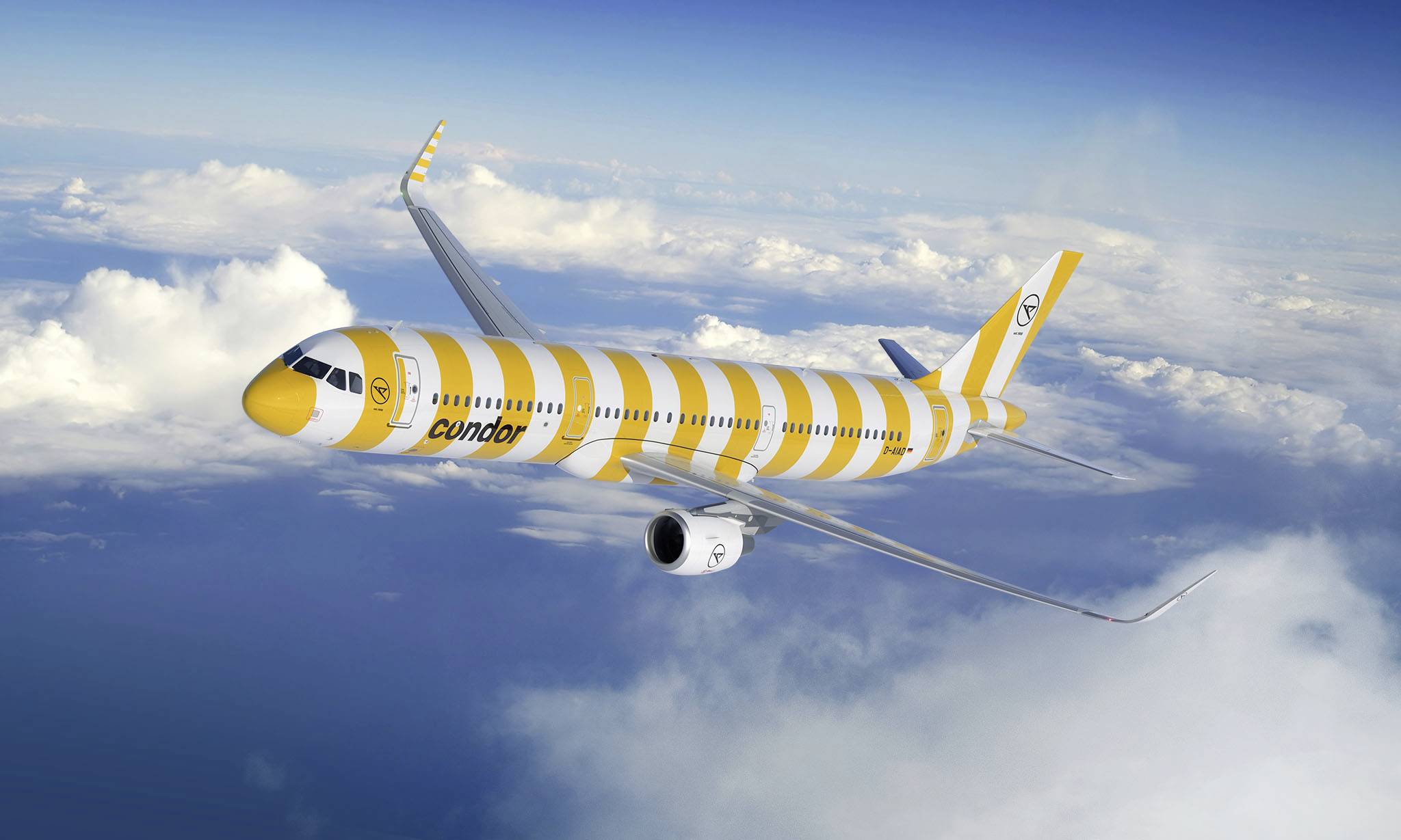 Żółto-biało prążkowany samolot pasażerski leci wysoko ponad chmurami na błękitnym niebie.