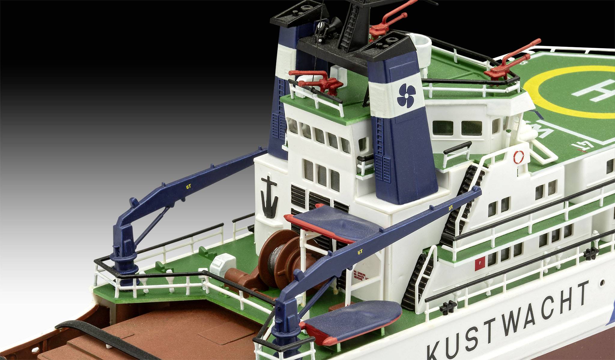 Model statku straży przybrzeżnej z lądowiskiem dla śmigłowców, niebieskimi dźwigami i łodziami ratunkowymi na pokładzie, biały kadłub z napisem 'KUSTWACHT'.