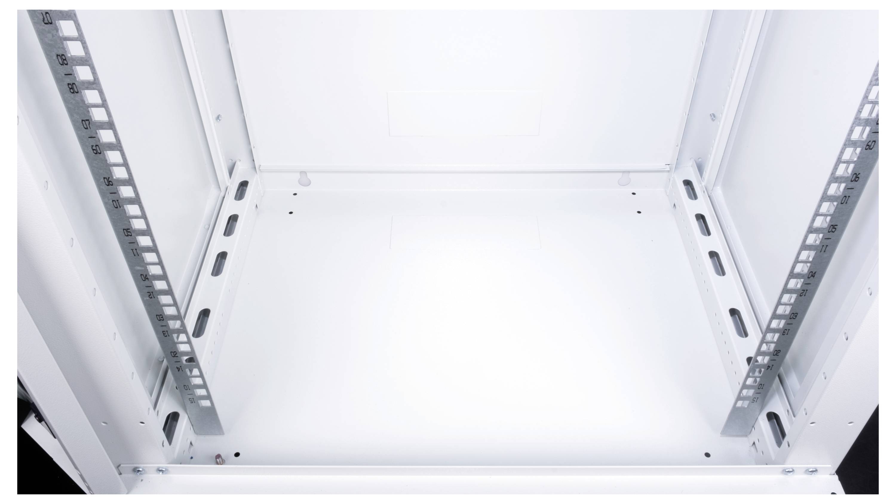 Pusty, biały stojak na sprzęt z metalowymi szynami, przygotowany do instalacji urządzeń elektronicznych, widziany od przodu.