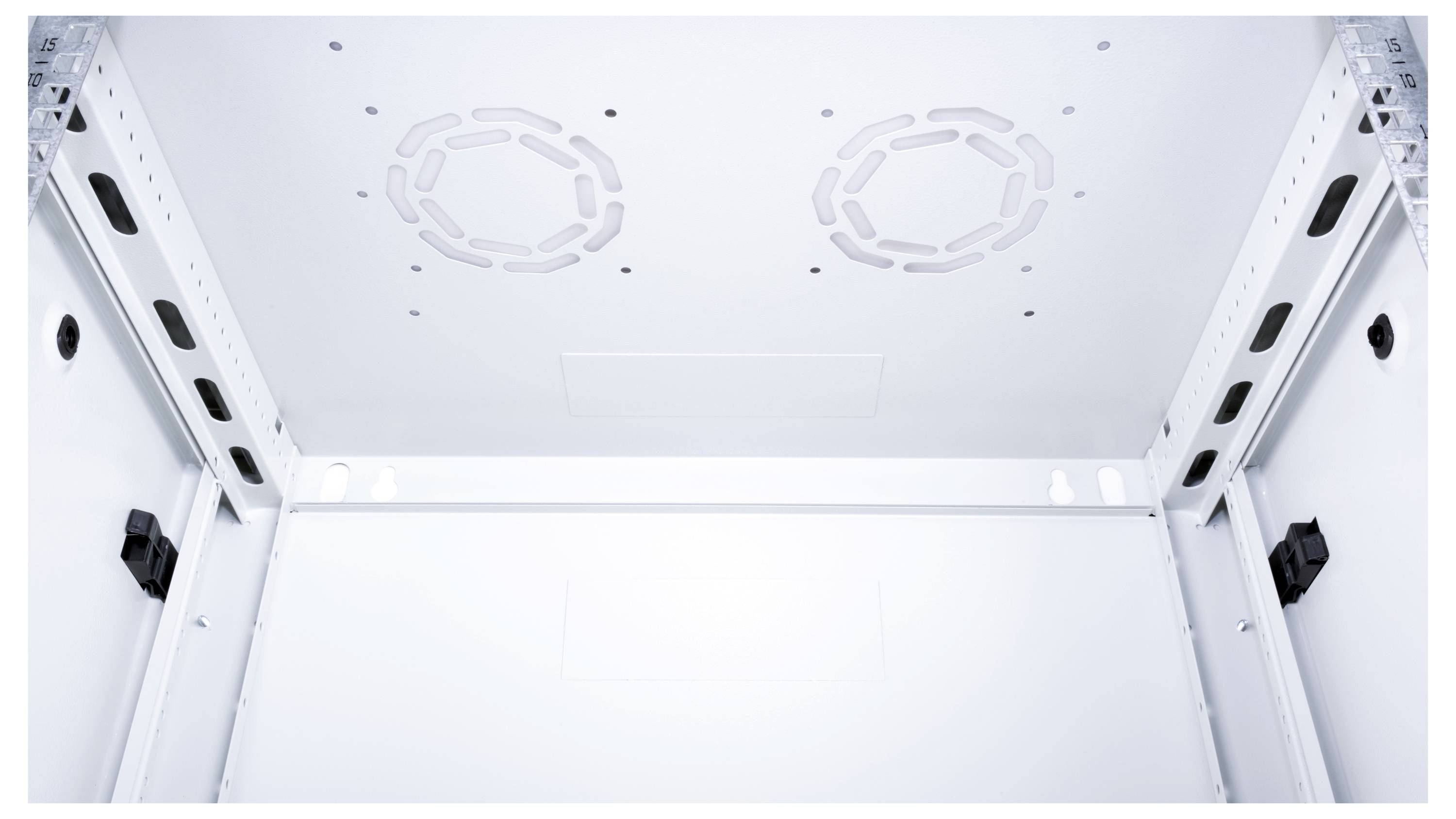 Wnętrze białej szafy serwerowej z widocznymi górnymi panelami wentylacyjnymi i bocznymi szynami montażowymi, przygotowanej do instalacji sprzętu.