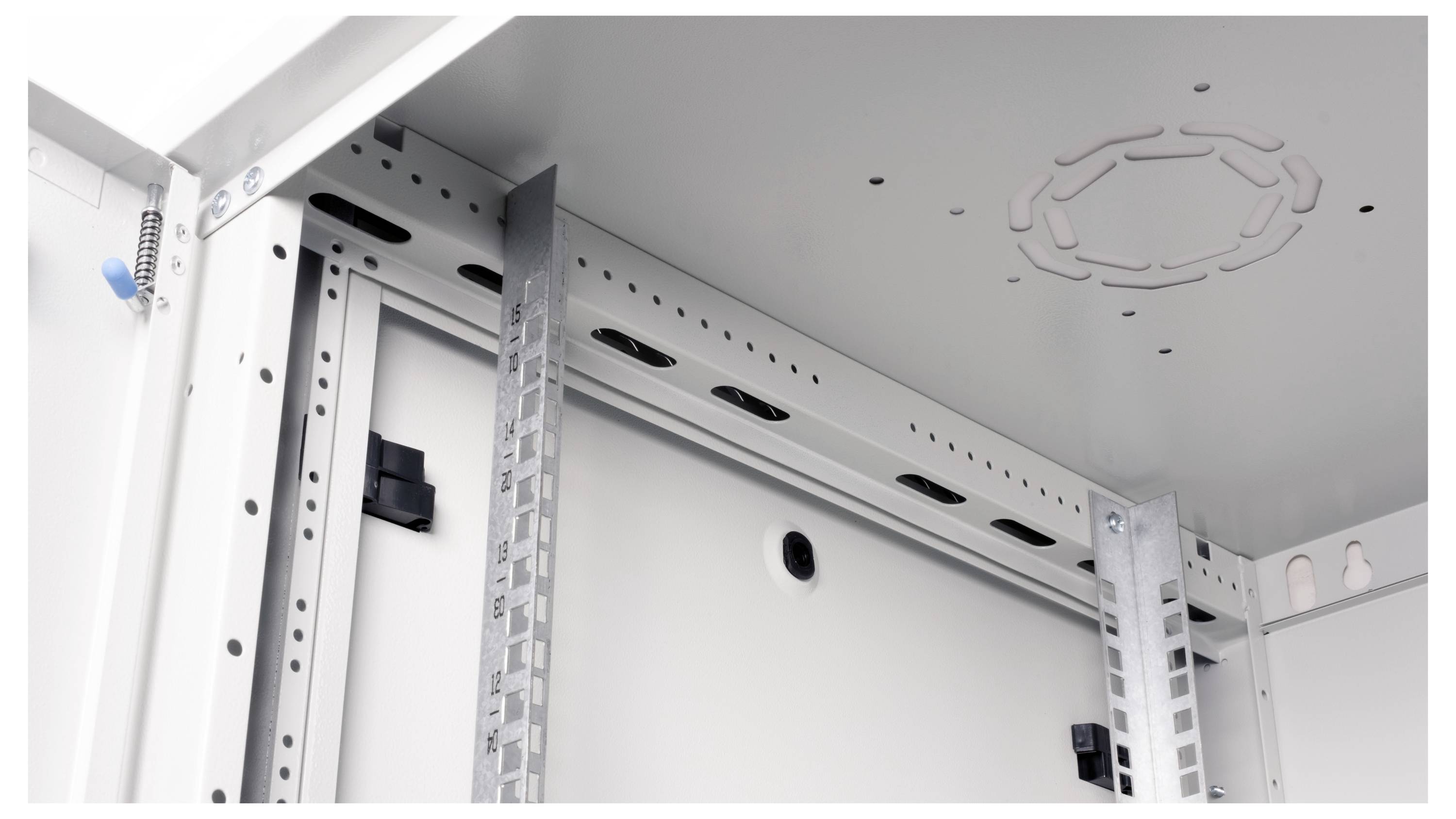 Obraz przedstawia wnętrze metalowej szafy serwerowej z szynami montażowymi i otworami do prowadzenia przewodów na górnym panelu.