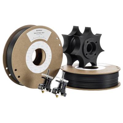 Filament do druku 3D na szpulach, w kolorze czarnym. Obok leżą dwa koła zębate wydrukowane w technologii 3D oraz dwie dysze drukarki do użycia.
