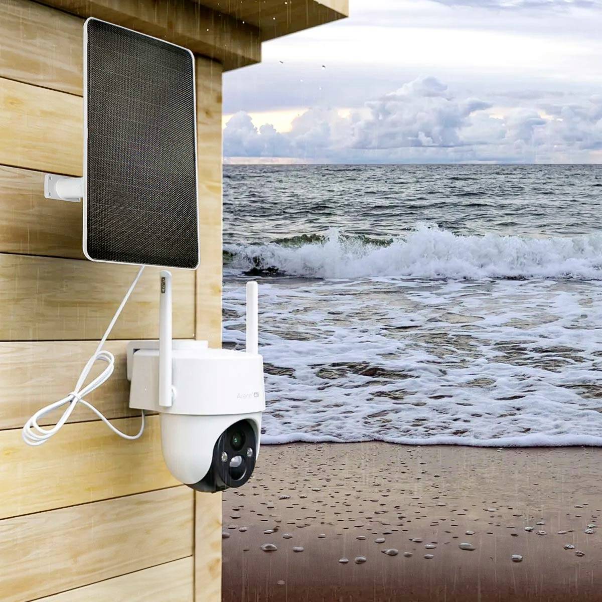 Kamera z panelem słonecznym na ścianie drewnianego domu, w tle morze z falami.