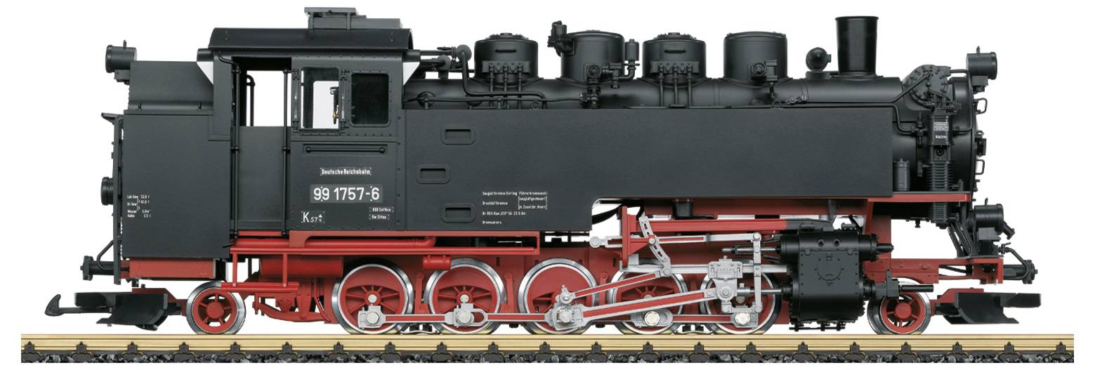 Historyczna lokomotywa parowa na torach, w czarnym lakierze z czerwonymi detalami. Widoczne liczne rury i mechanizmy.