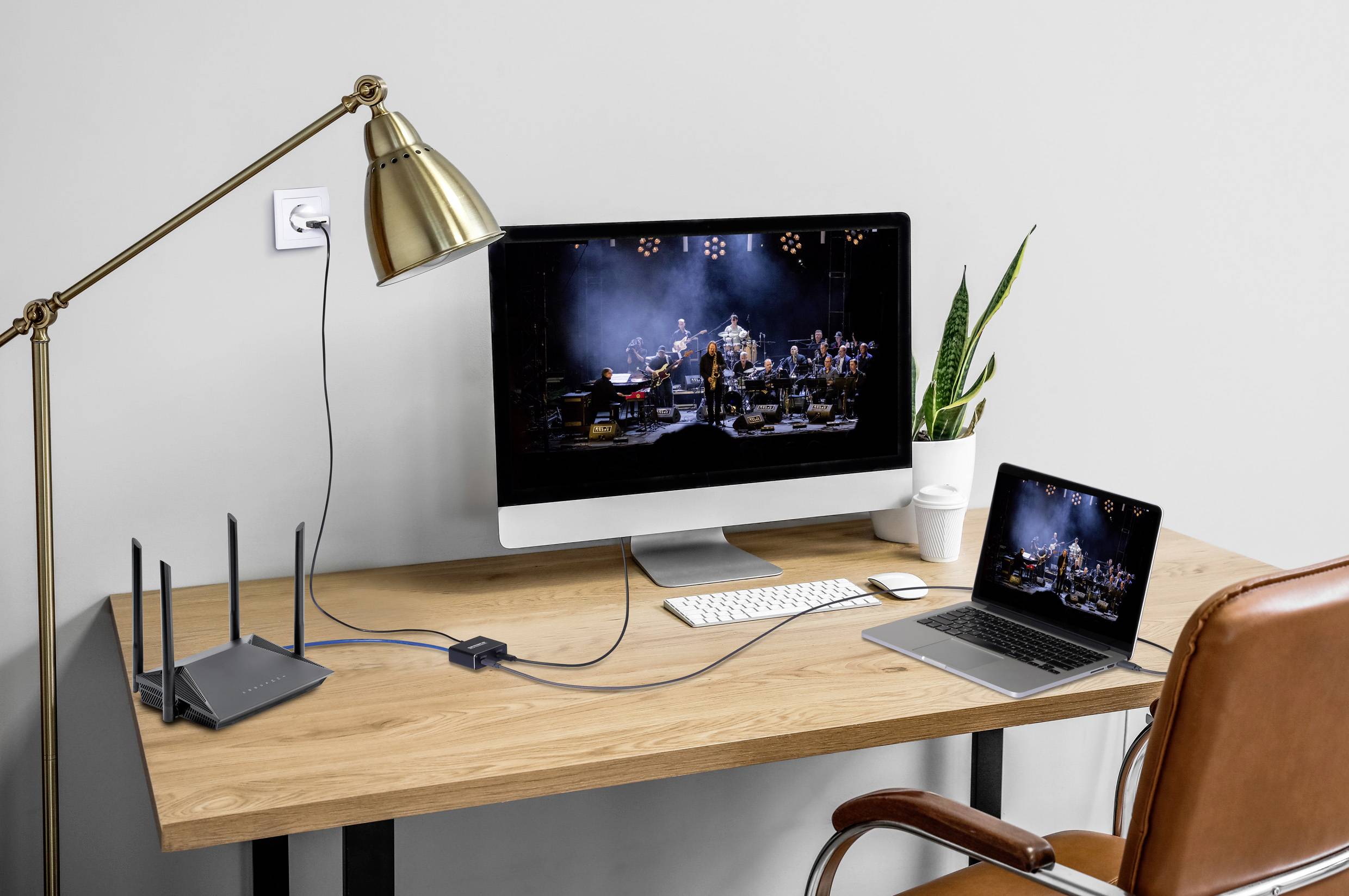 Domowe biuro z monitorem stacjonarnym i laptopem wyświetlającymi orkiestrę, klawiaturą, myszką, lampą i rośliną na drewnianym biurku.
