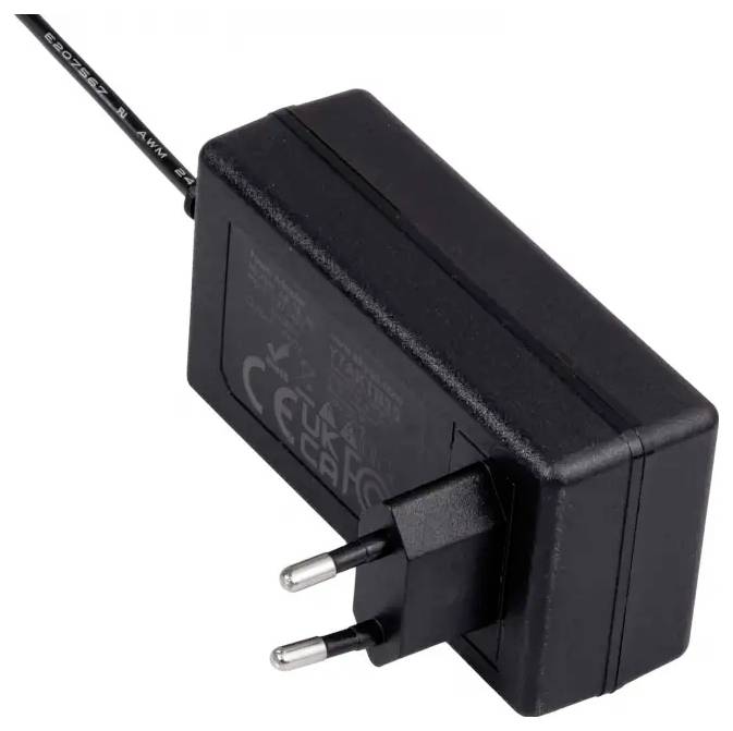 Czarny zasilacz z europejską wtyczką i kablem. Na powierzchni widoczne są informacje dotyczące bezpieczeństwa i oznaczenia.