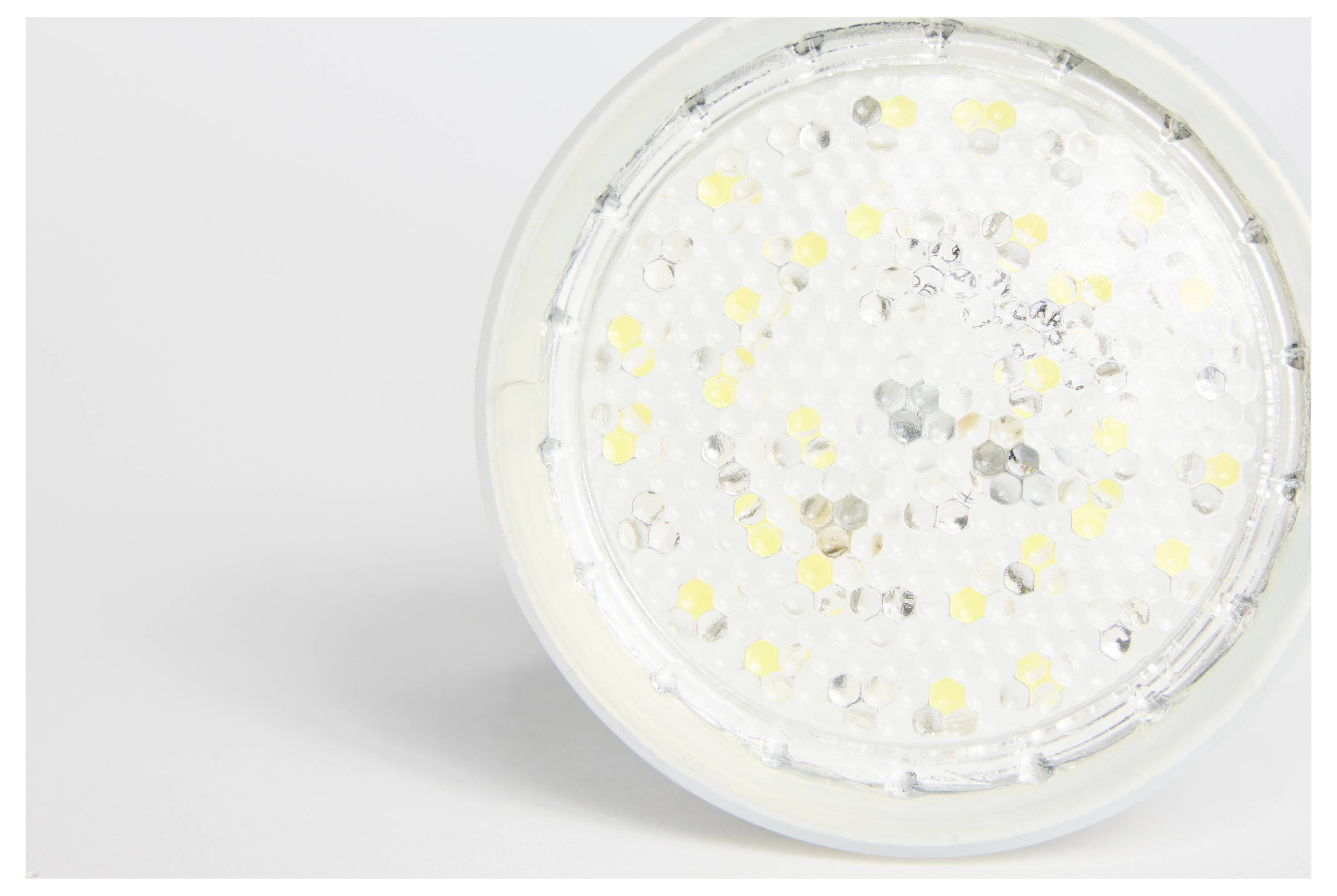 Zbliżenie żarówki LED z widocznymi żółtymi i srebrnymi diodami na białym tle.