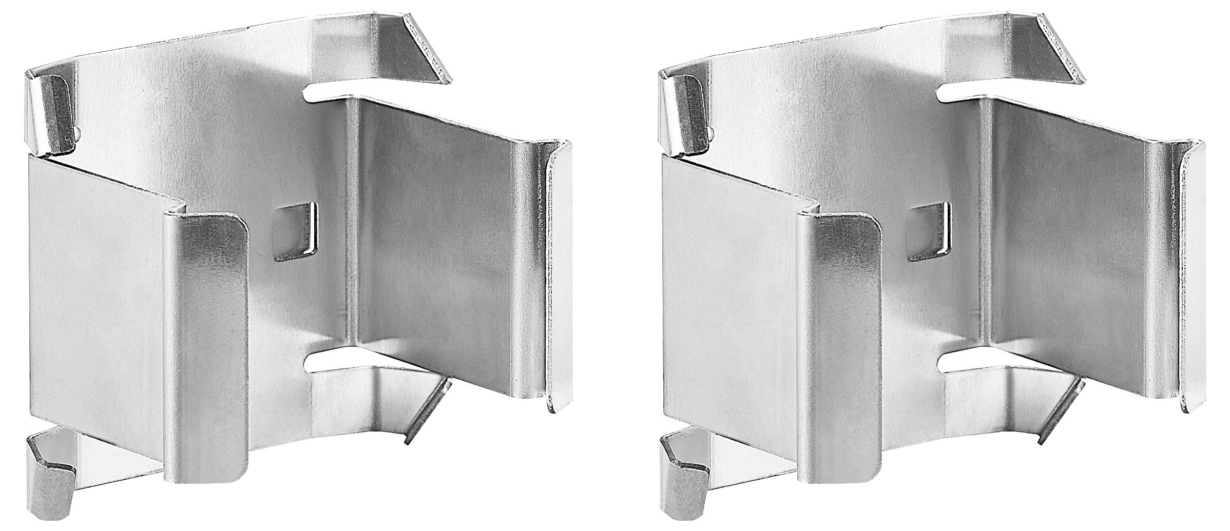 Dwie metalowe części montażowe obok siebie. Są srebrnego koloru, identyczne i posiadają liczne zagięcia oraz krawędzie.