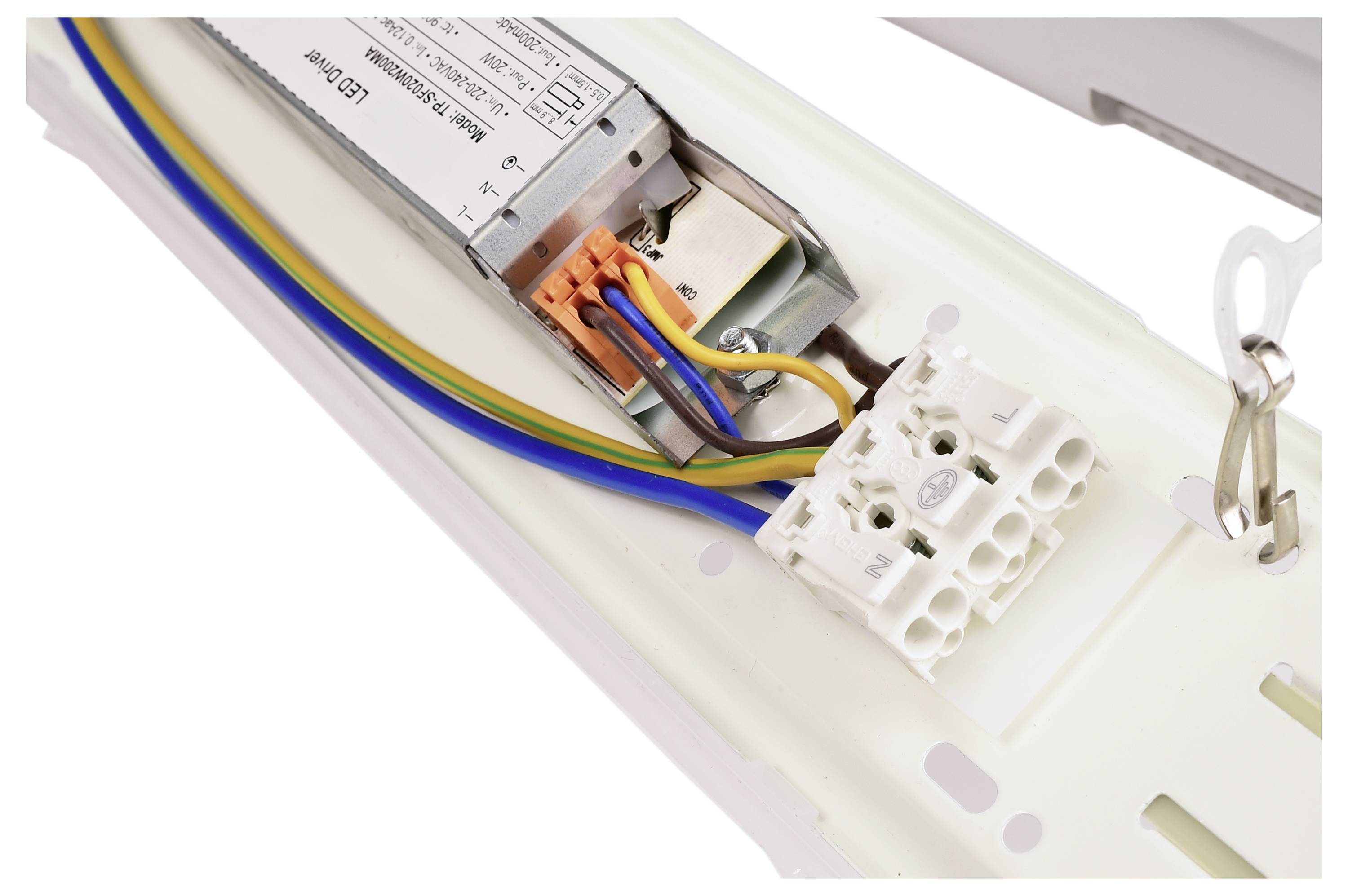 Zbliżenie elektrycznego przyłącza w lampie, pokazujące kable w różnych kolorach połączone ze złączem.