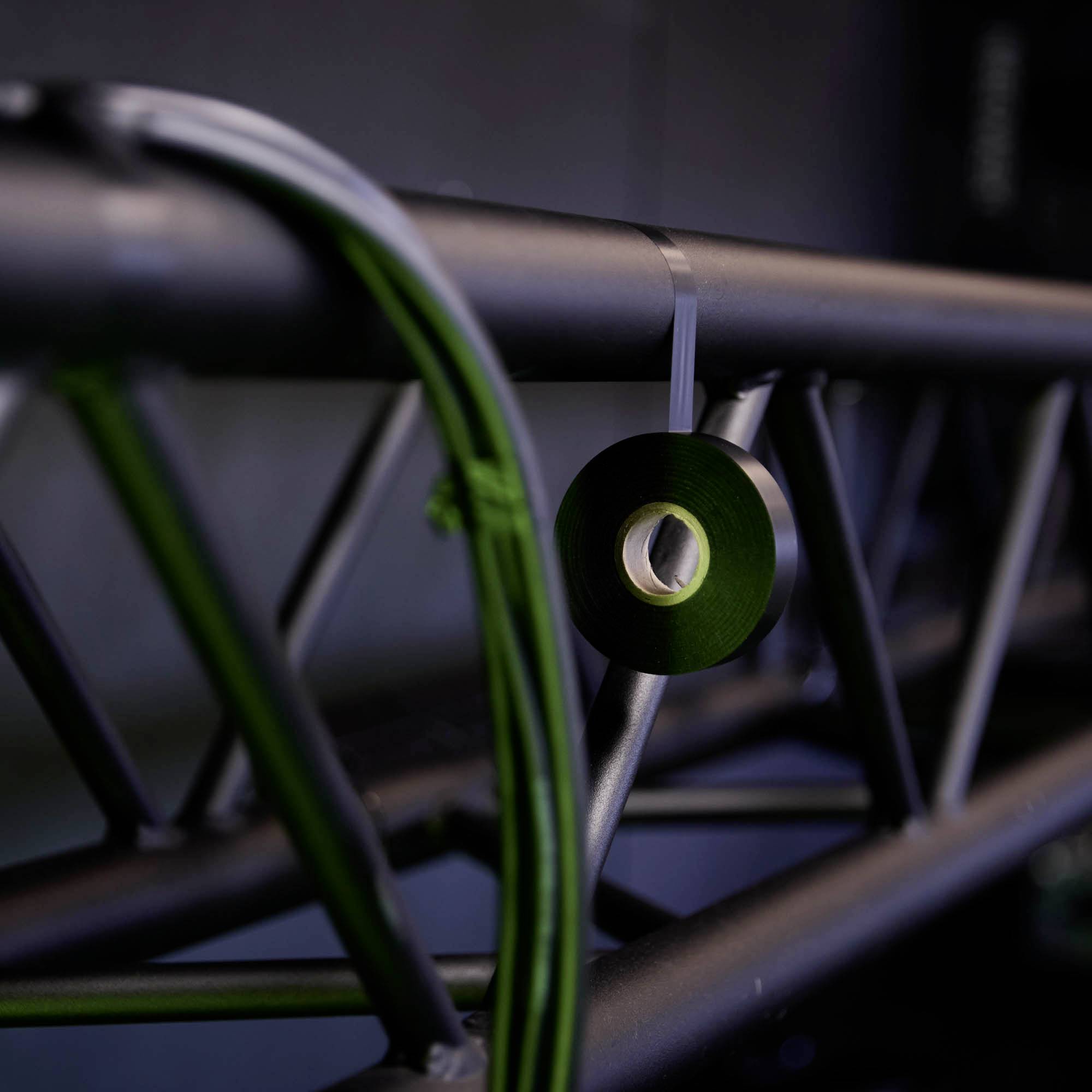 Zbliżenie na konstrukcję oświetleniową sceny z uchwytem na kable w ciemnym otoczeniu.