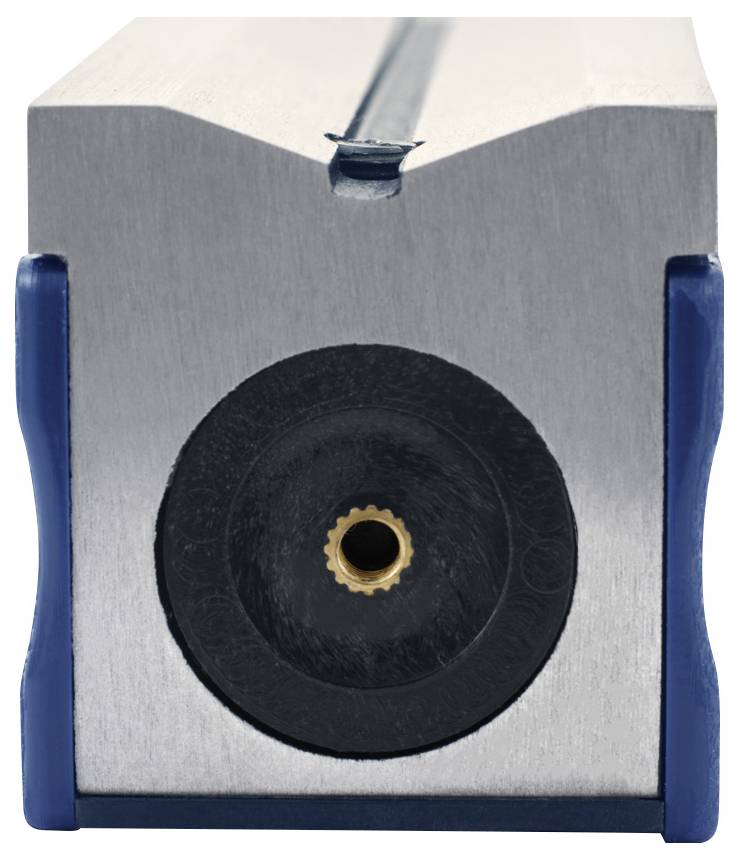 Zbliżenie metalowego prostokątnego urządzenia z centralnym czarnym elementem o kształcie koła, z małym mosiężnym złączem, na neutralnym tle.