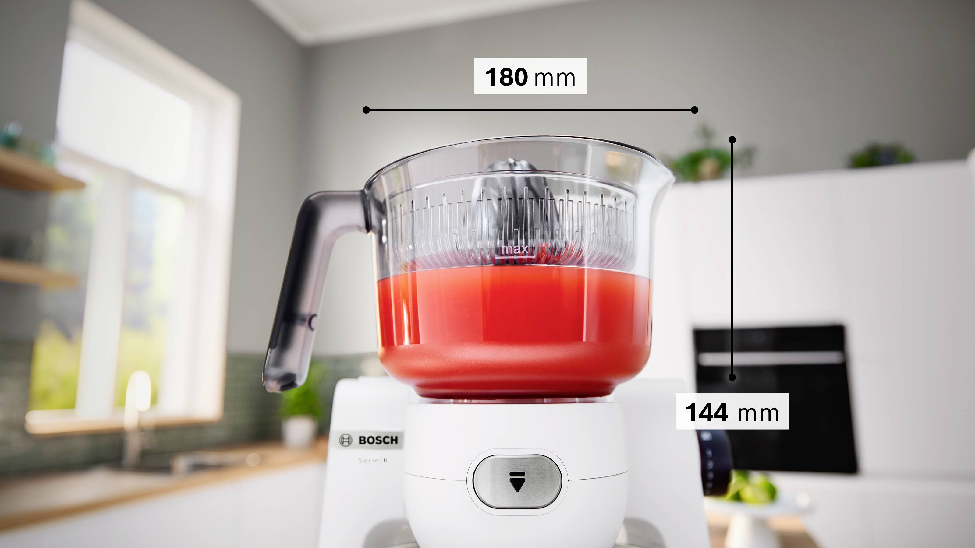 Przedstawiono mikser z przezroczystą miską zawierającą czerwoną ciecz. Szerokość miski oznaczona jest jako '180 mm', a wysokość jako '144 mm'.