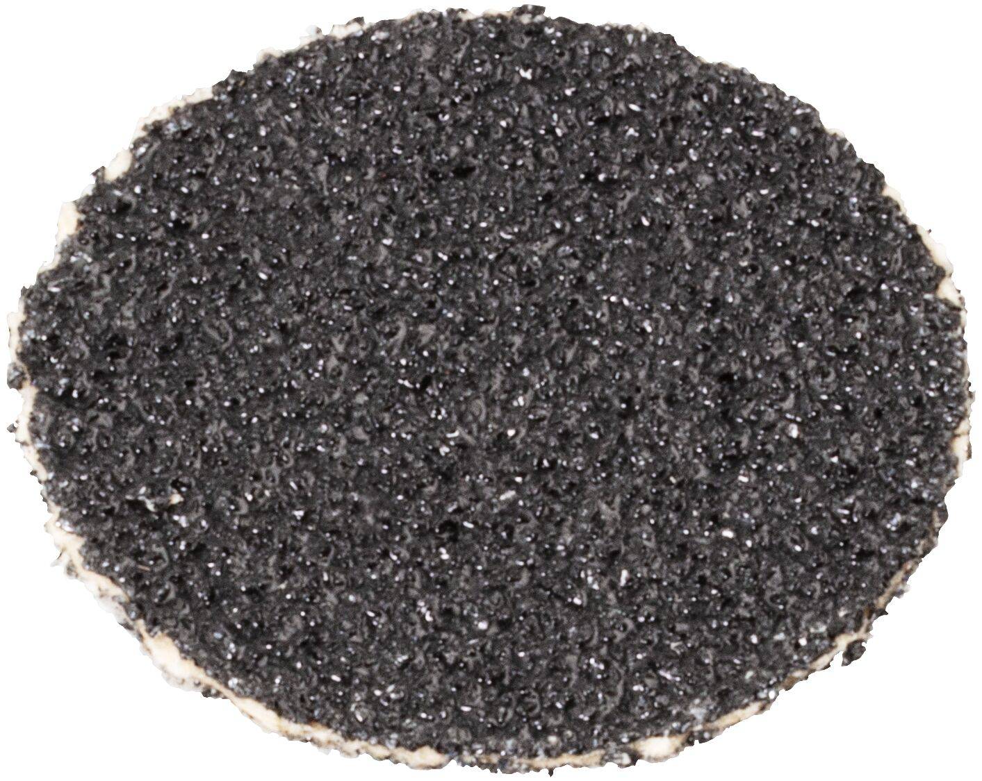 Teksturowana, okrągła, szorstka czarna powierzchnia, prawdopodobnie próbka asfaltu lub podobnego materiału, sfotografowana z góry, na białym tle.