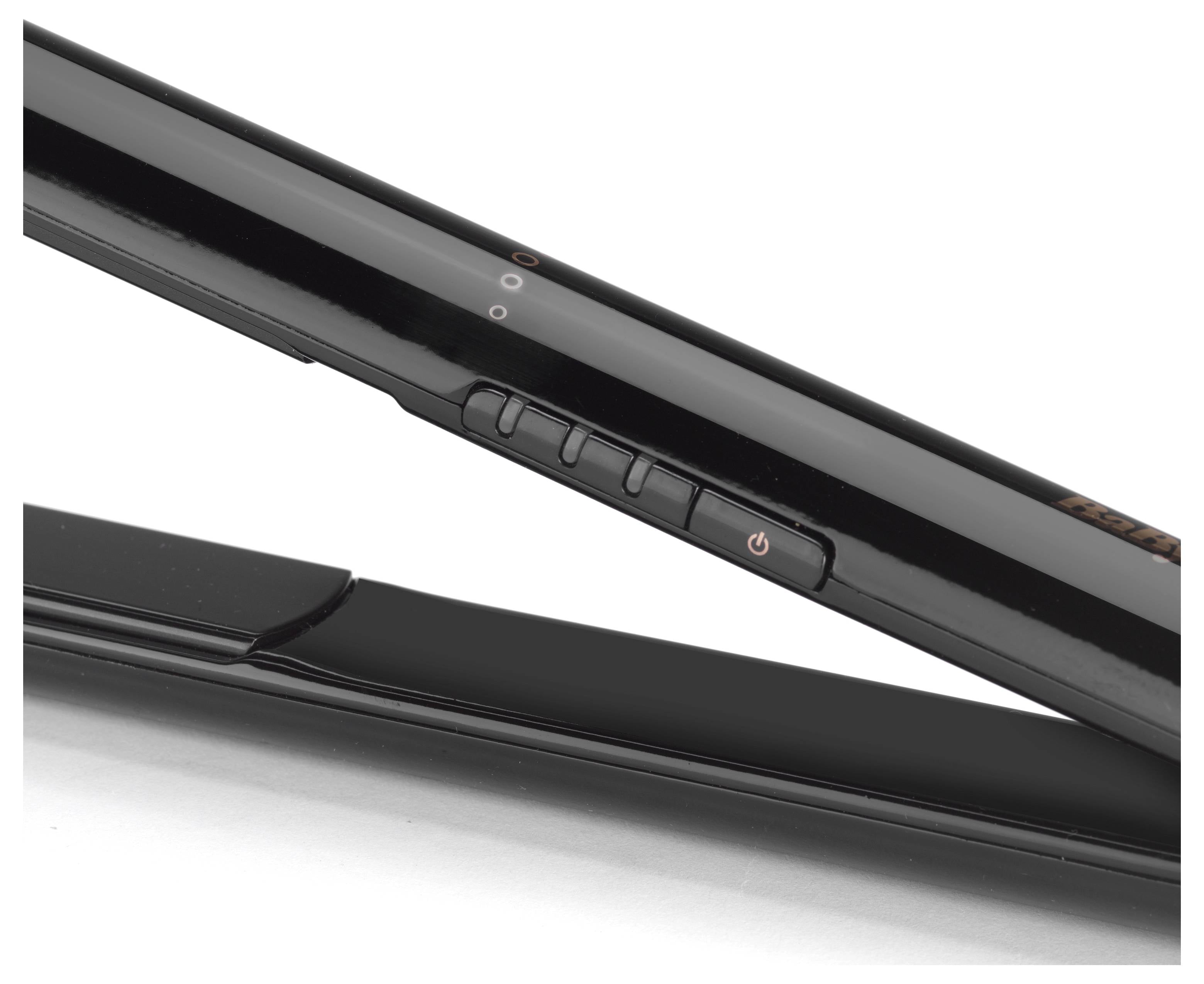 Zbliżenie na czarną prostownicę do włosów, z widocznymi przyciskami włączania i regulacji temperatury na bocznym uchwycie.