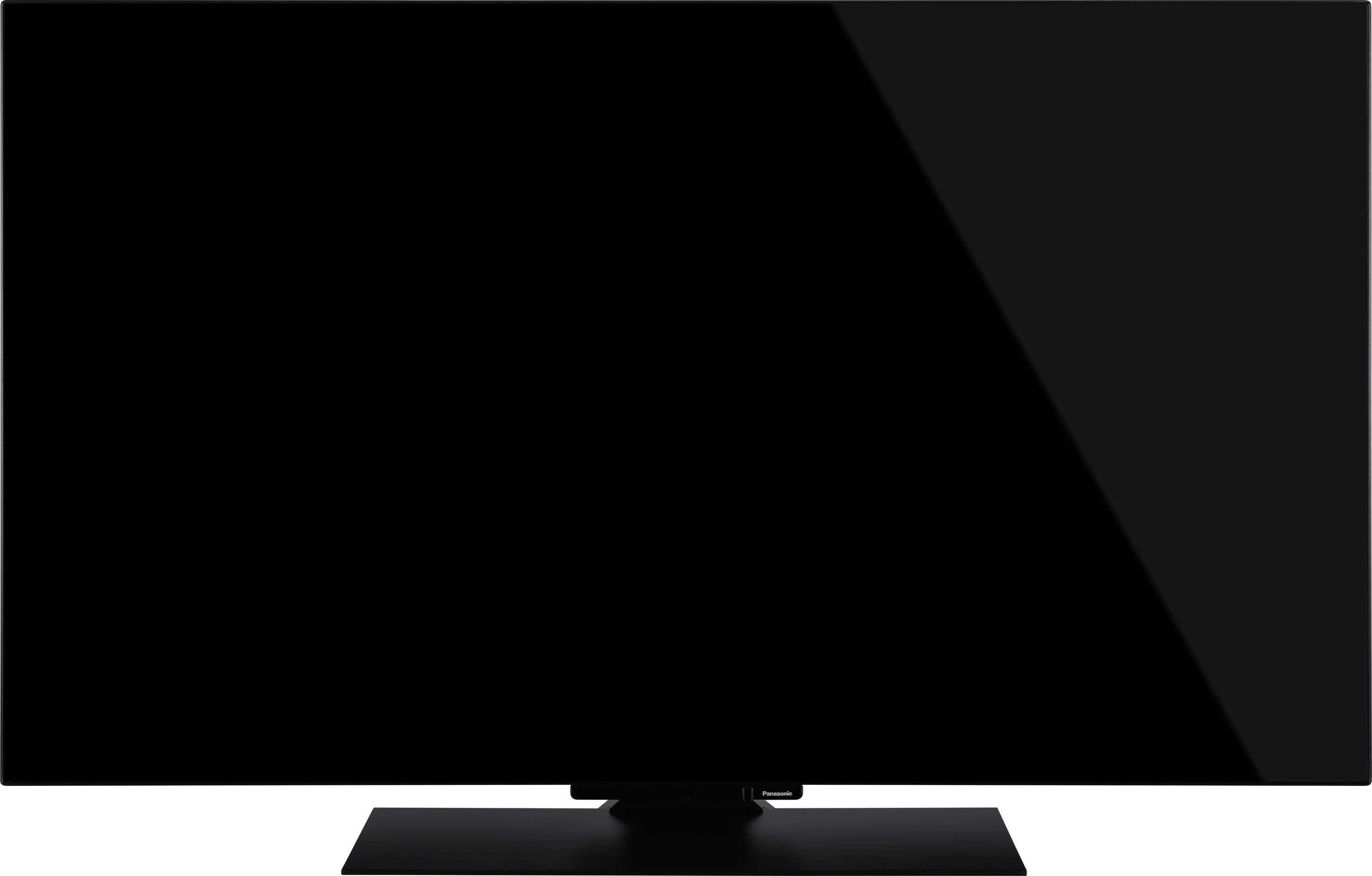 Telewizor z płaskim ekranem z czarnym, błyszczącym wyświetlaczem, zamontowany na prostokątnej podstawie. Ekran jest wyłączony, odbijając minimalne światło.