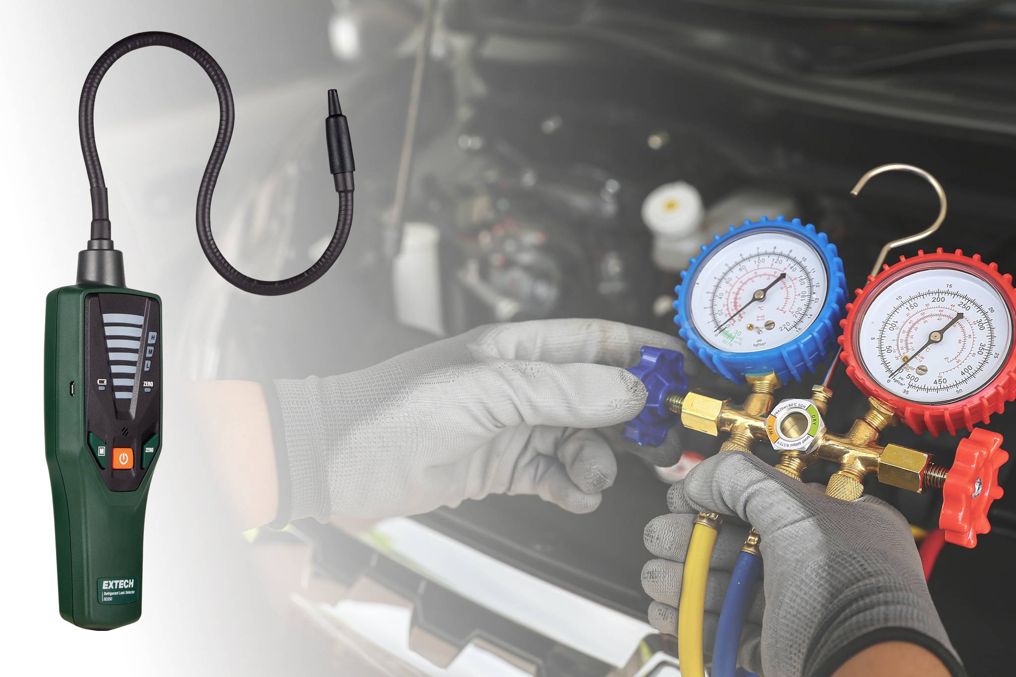 'Ręce mechanika samochodowego regulują wskaźniki na manometrze klimatyzacji, sprawdzając poziomy ciśnienia. Po lewej stronie widoczne narzędzie do wykrywania wycieków.'