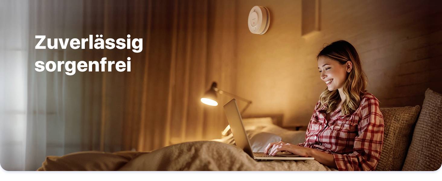 Uśmiechnięta kobieta siedzi na łóżku i korzysta z laptopa. Po lewej stronie widnieje tekst 'Niezawodnie bez obaw'.