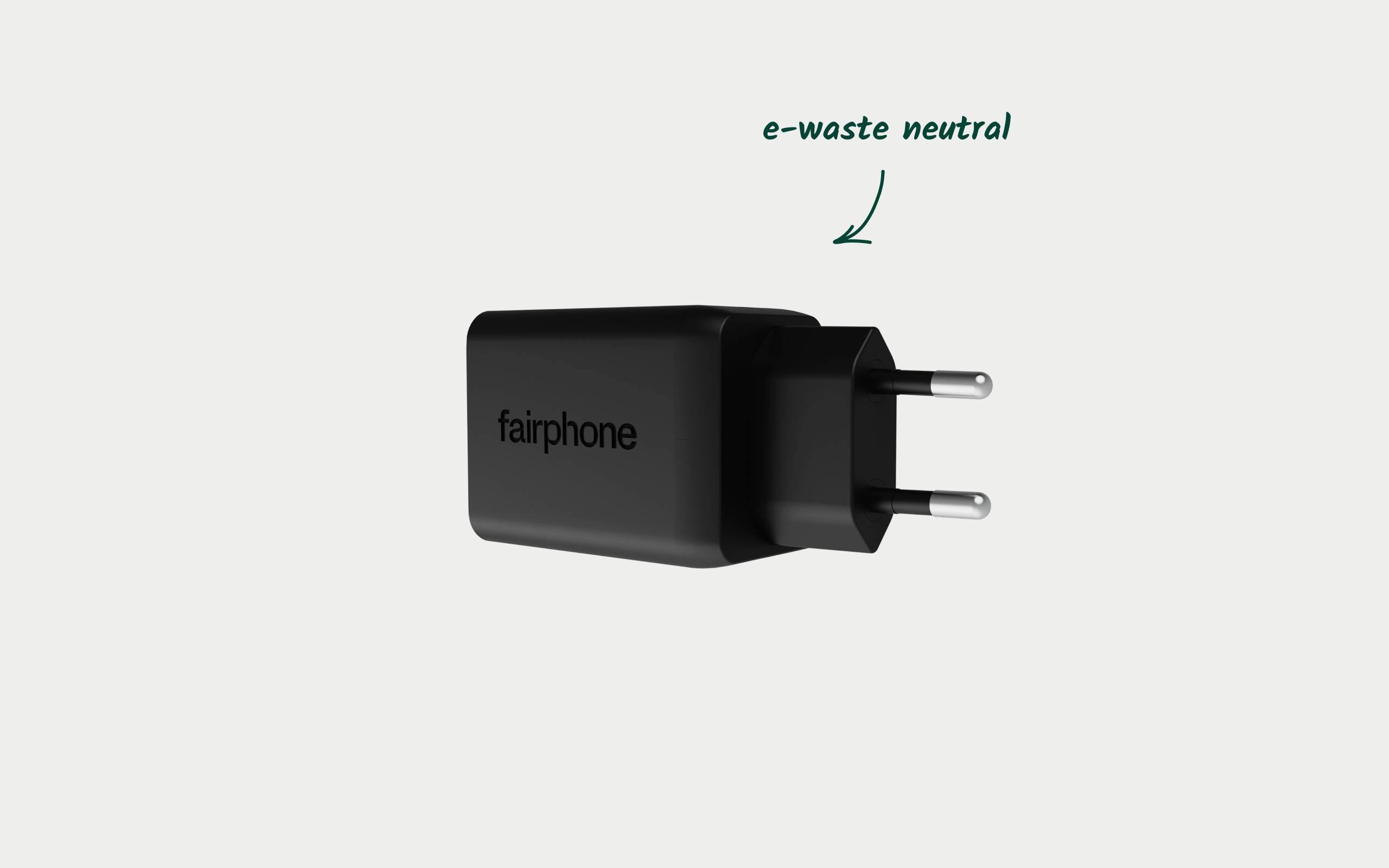 Czarna ładowarka Fairphone z wtyczką europejską. Oznaczenie wskazuje na 'neutralność e-waste', co sugeruje ekologiczny projekt.