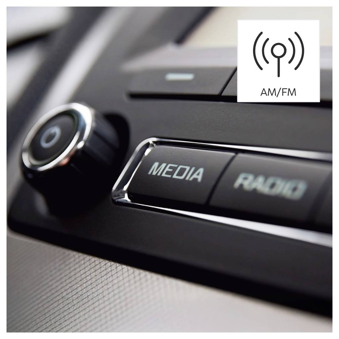 Zbliżenie deski rozdzielczej radia samochodowego z przyciskami 'MEDIA' i 'RADIO' oraz pokrętłem. W prawym górnym rogu ikona AM/FM.