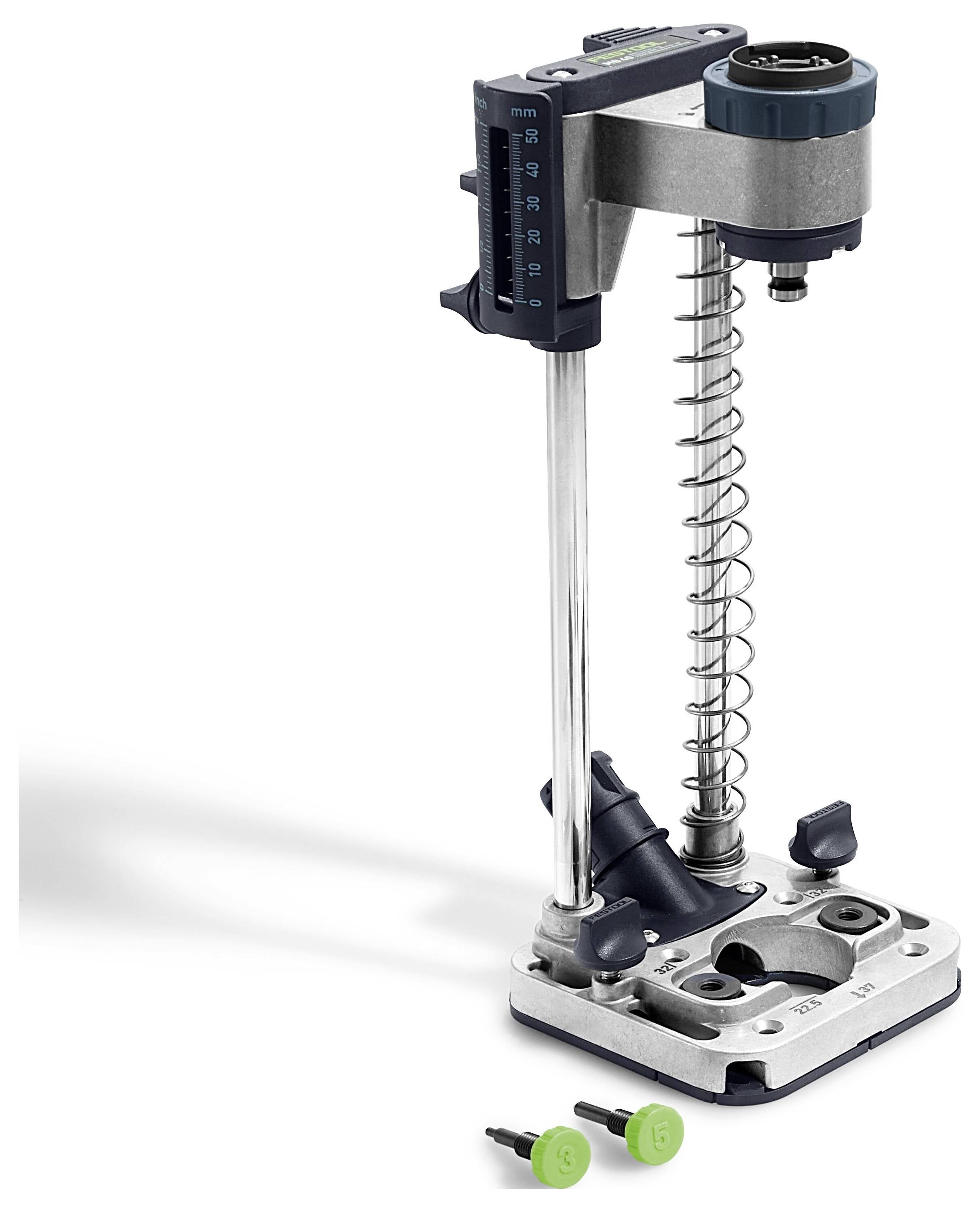 Metalowy prowadnik wiertarski z regulowaną linijką pionową, mechanizmem sprężynowym oraz dwoma zielonymi uchwytami do precyzyjnego wiercenia.