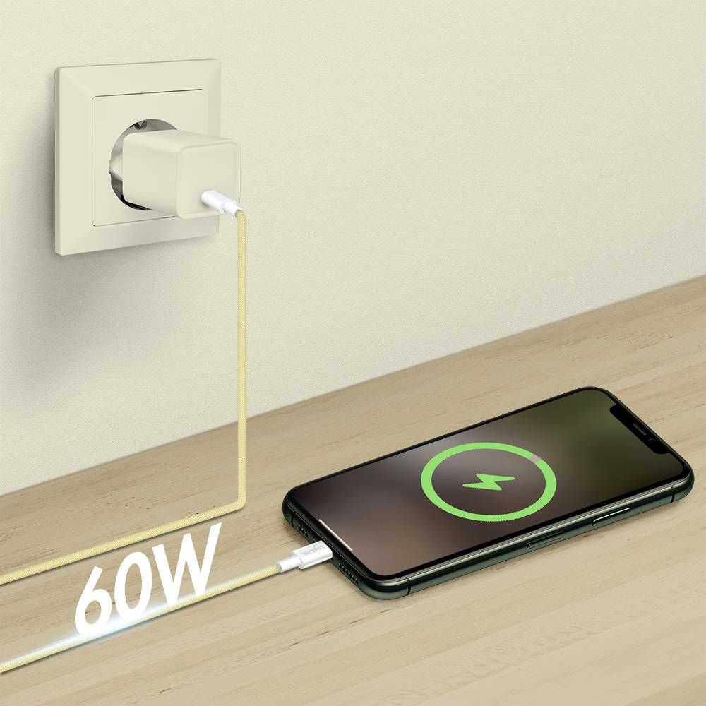 Smartfon na drewnianej powierzchni ładuje się przez wtyczkę adaptera o mocy 60W podłączoną do gniazdka ściennego, wyświetlając na ekranie symbol ładowania.