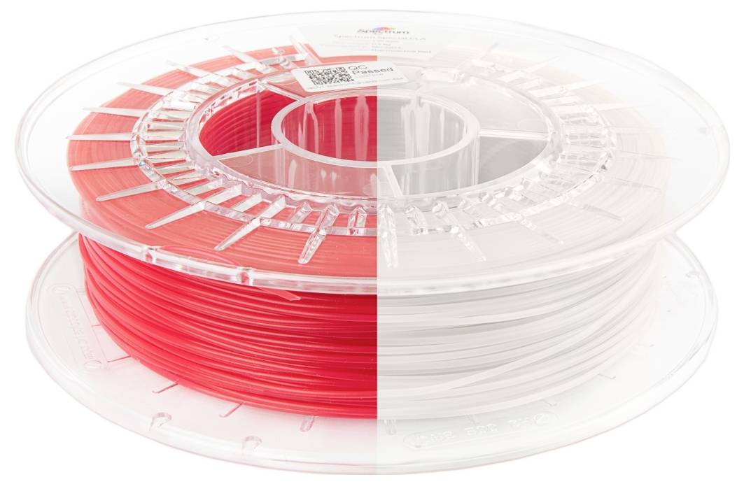 Dwie szpule włókna drukarki 3D ustawione obok siebie, jedna czerwona, druga biała, prezentujące opcje kolorystyczne materiałów do druku 3D.