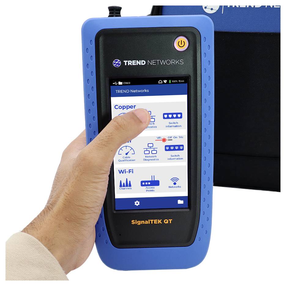 Dłoń trzyma niebieski tester sieci, który wyświetla ikony połączenia Wi-Fi i transmisji danych na swoim ekranie. Urządzenie jest oznaczone etykietą 'SignalTEK QT'.