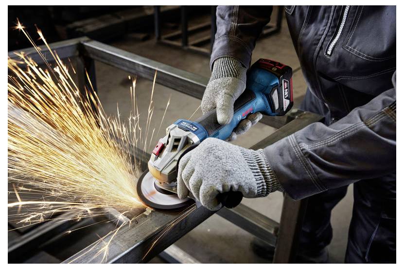 Osoba w sprzęcie ochronnym używa szlifierki kątowej na metalu, tworząc jasne iskry.