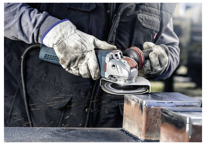 Osoba w ochronnych rękawicach używa szlifierki kątowej na metalowej powierzchni, z lecącymi iskrami. Fokus jest na narzędziu i wykonywanej pracy.