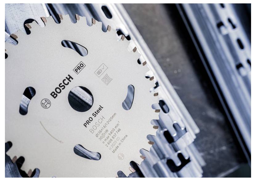 Tarcza piły tarczowej z logo 'Bosch Pro Steel' umieszczona jest na kawałkach szyny metalowej, sugerując jej przeznaczenie do cięcia materiałów metalowych.