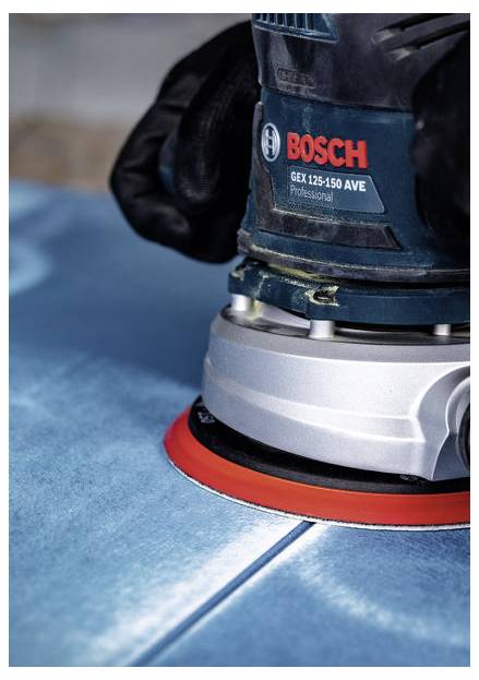 Osoba ubrana w czarne rękawice używa szlifierki Bosch GEX 125-150 AVE Professional na niebieskiej powierzchni, koncentrując się na wygładzaniu materiału.