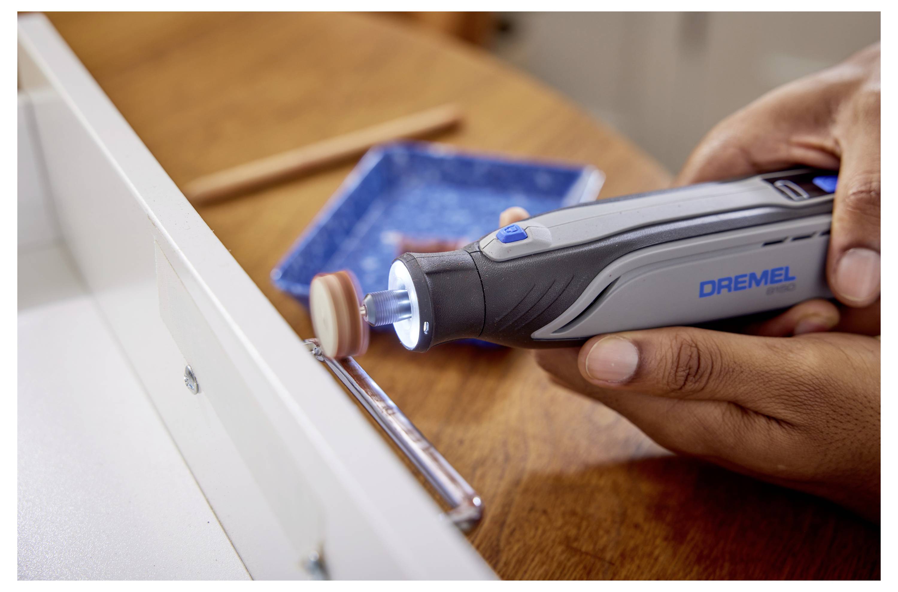 Osoba używająca narzędzia obrotowego z nakładką polerską na klamce szuflady.